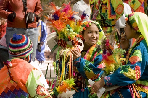 Girl in traditional dress surrounded by dancers